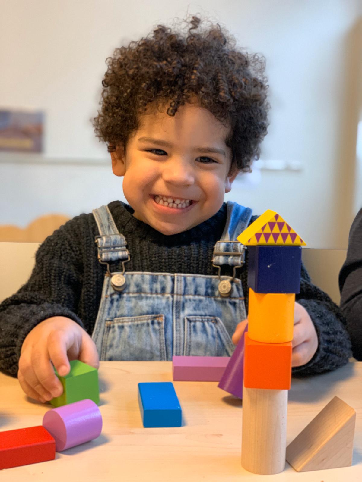 Kind speelt met blokken en lacht